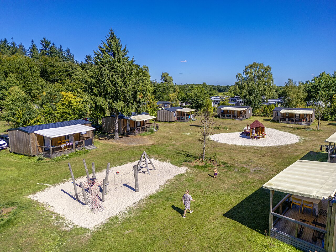 Wooden chalets, kids' play areas at CAPFUN De Belten campsite in Rheeze.