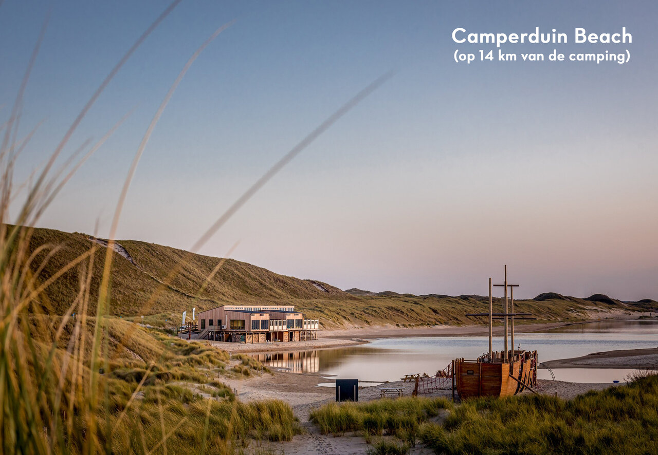 Camperduin Beach with dunes, modern building and play boat, near Schoorl.