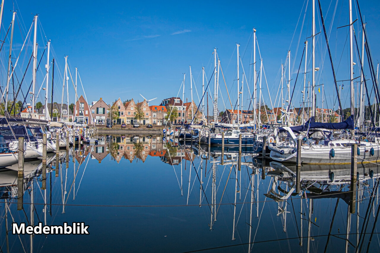 Historic marina of Medemblik with sailboats and traditional Dutch houses.
