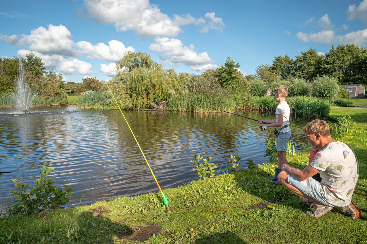 Father and son fishing in the pond at CAPFUN De Bongerd, Tuitjenhorn.
