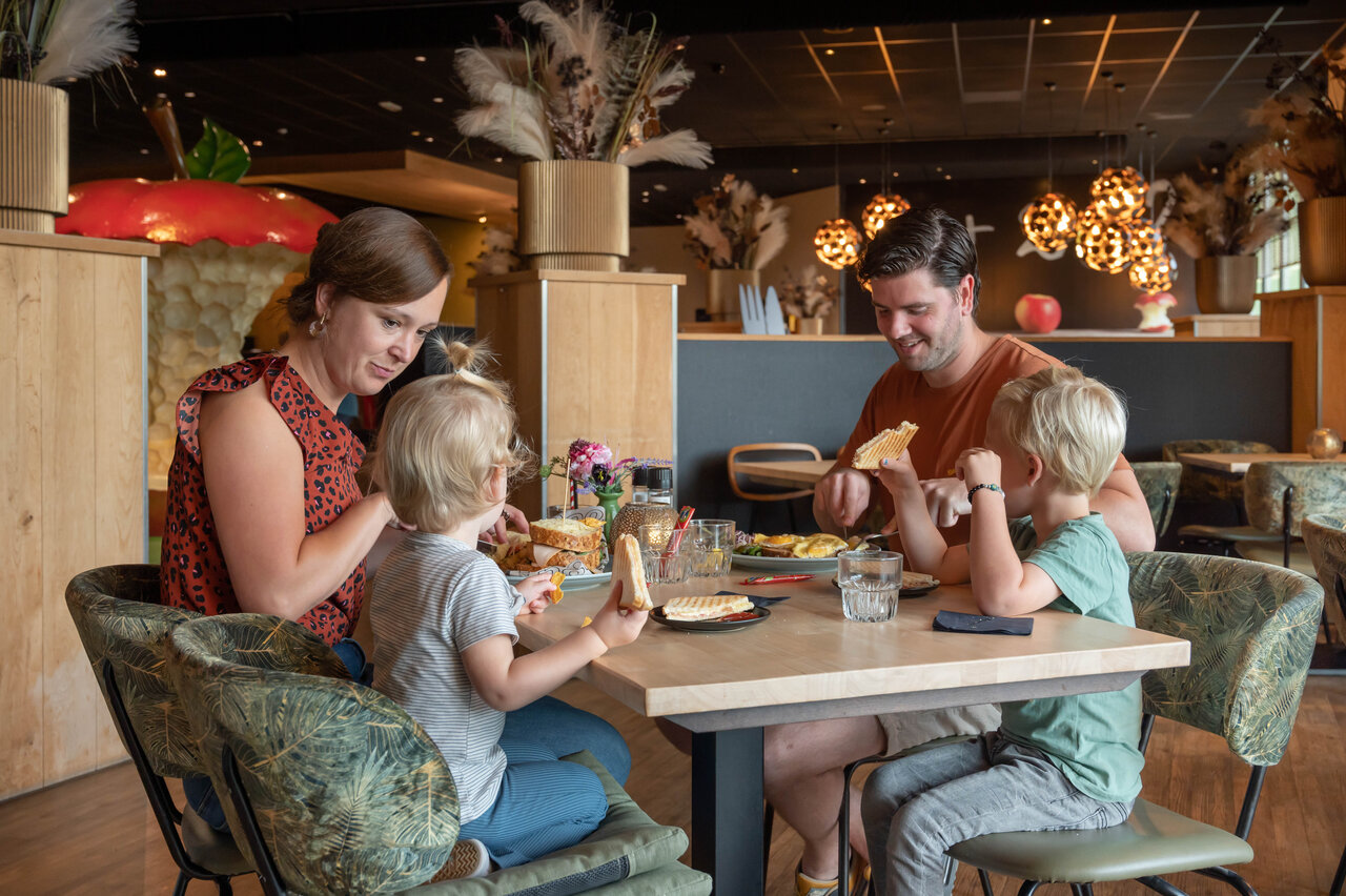 Family with children having lunch at the restaurant of CAPFUN De Bongerd campsite in Tuitjenhorn.