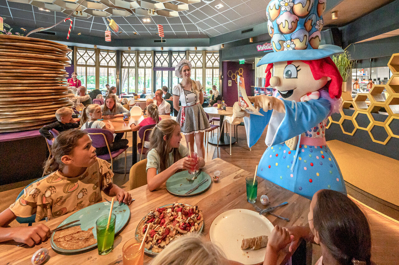 Children and Wafelie mascot in the restaurant at CAPFUN De Bongerd campsite in Tuitjenhorn.