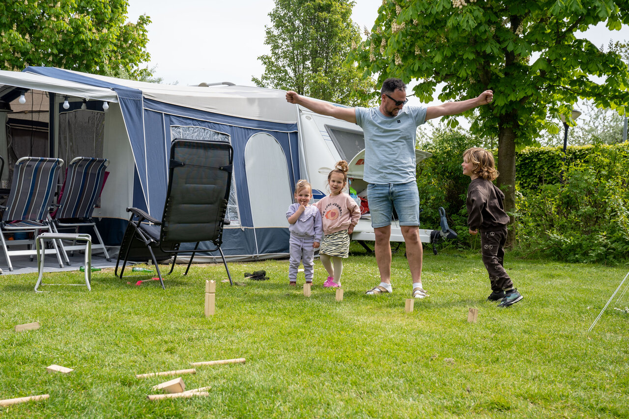 Family playing Kubb game at CAPFUN De Bongerd campsite in Tuitjenhorn.