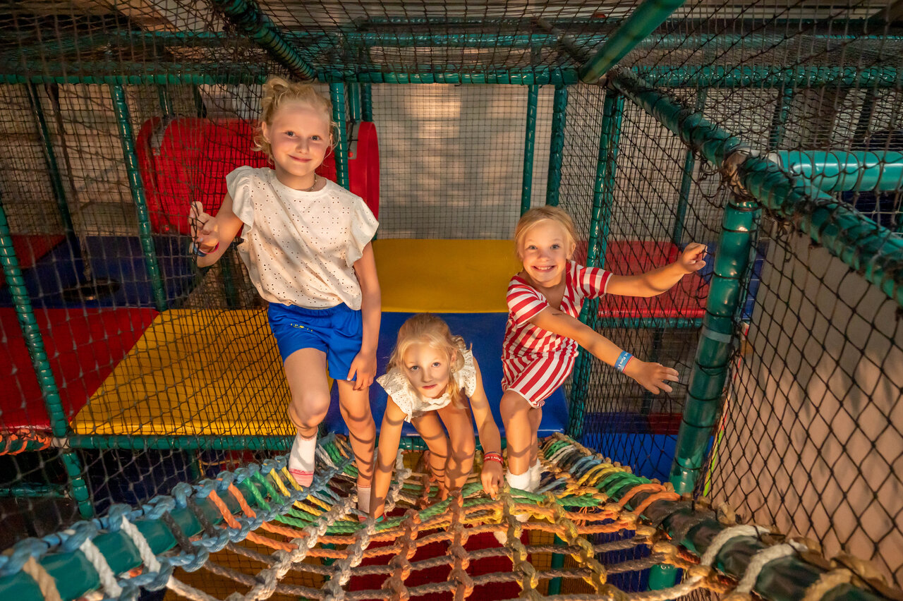 Indoor play area with smiling children at CAPFUN De Bongerd campsite in Tuitjenhorn.