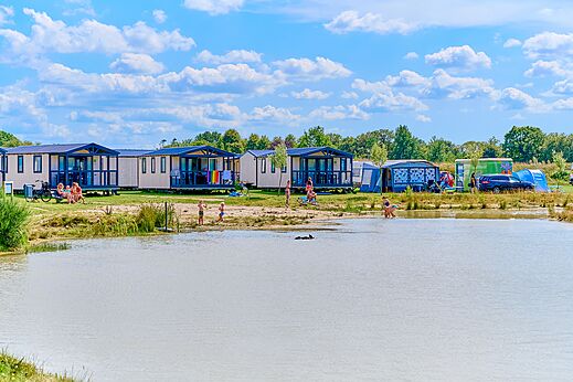 Mobile homes and lake at CAPFUN De Eikenhof campsite in Paasloo/Oldemarkt.
