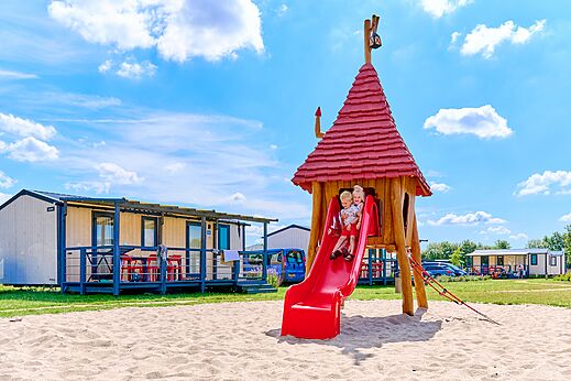 Children on red slide and playground at CAPFUN De Eikenhof campsite in Paasloo/Oldemarkt.