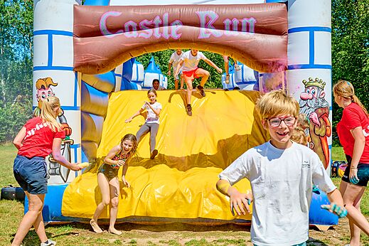 Children playing on the "Castle Run" inflatable castle at CAPFUN De Eikenhof campsite.