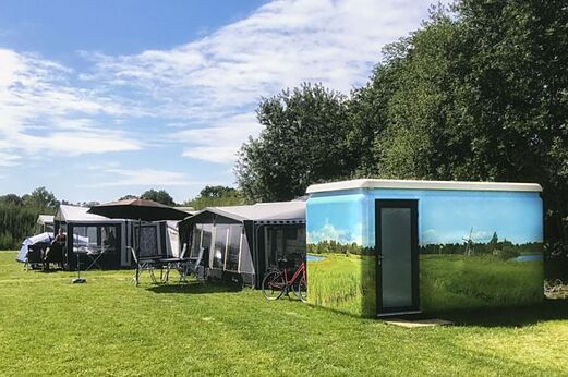 Decorated sanitary unit and green camping pitches at CAPFUN De Eikenhof campsite in Paasloo/Oldemarkt.