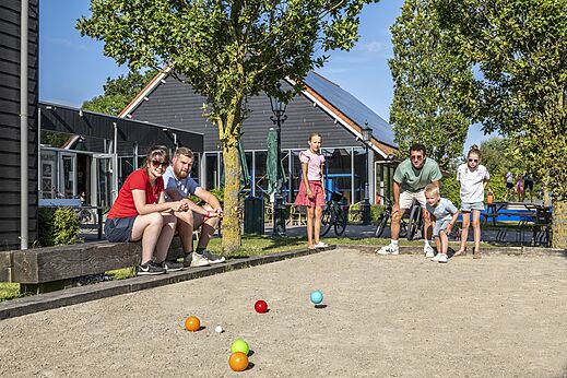 Family playing pétanque on the court at CAPFUN De Pekelinge in Oostkapelle.