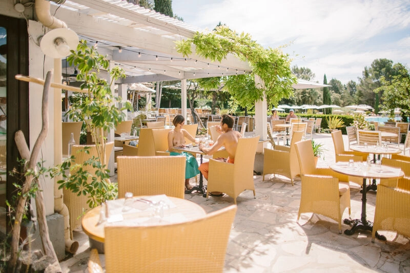 Naturist couple dining on shaded restaurant terrace, LIBRANOO Naturiste Belezy campsite in B�doin (84).