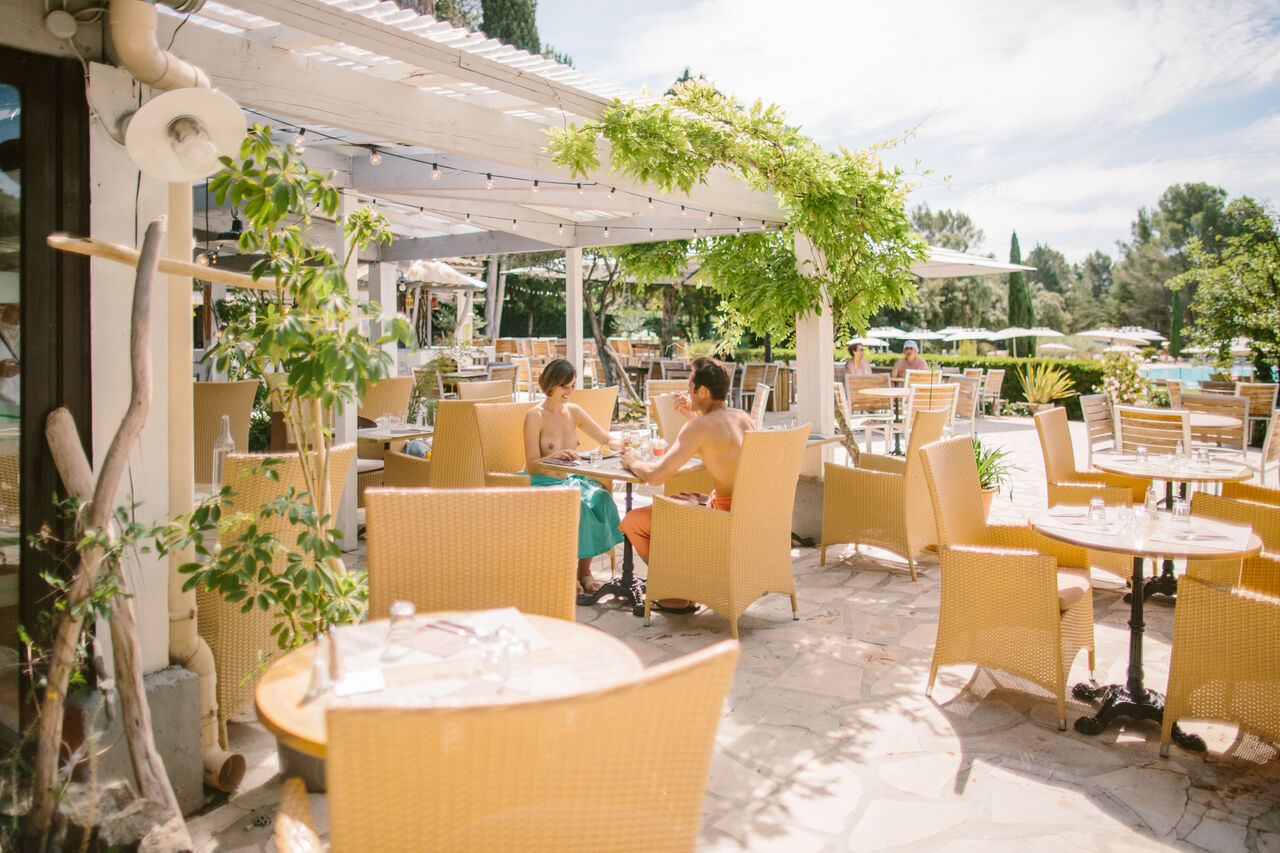 Naturist couple dining on shaded restaurant terrace, LIBRANOO Naturiste Belezy campsite in B�doin (84).