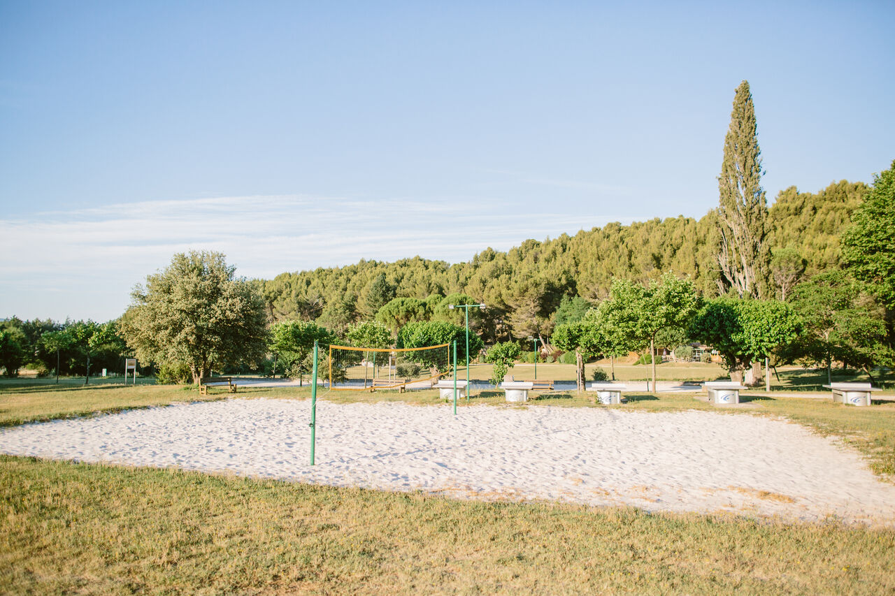 Beach volleyball court and ping-pong tables at LIBRANOO Naturiste Belezy campsite.
