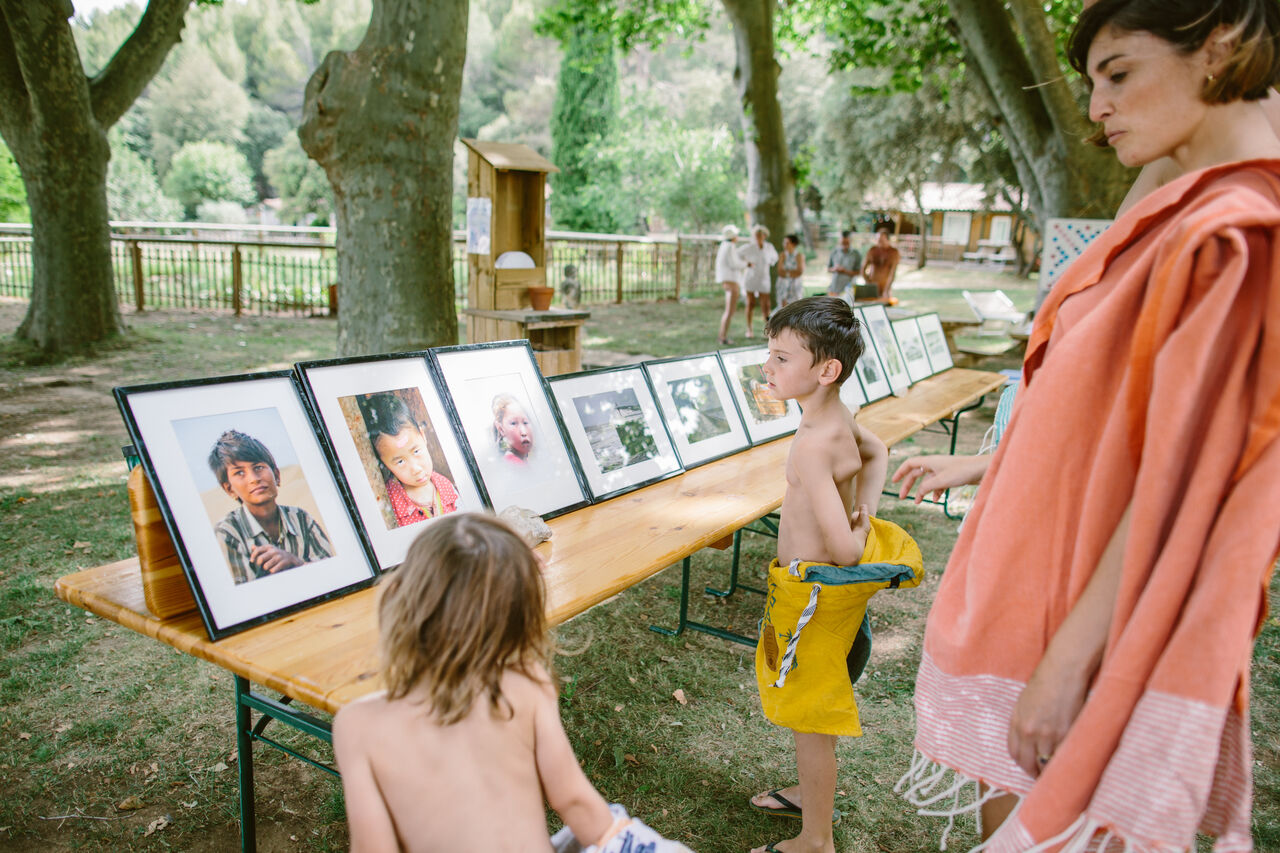 Children viewing outdoor photo exhibition at LIBRANOO Naturiste Belezy campsite in B�doin (84).