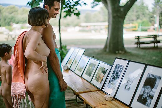 Naturist family viewing photo exhibition at LIBRANOO Naturiste Belezy campsite, Bédoin.