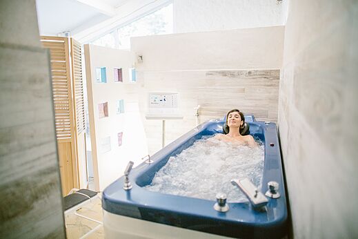 Woman relaxing in a hydrotherapy tub at LIBRANOO Naturiste Belezy campsite in Bédoin (84).