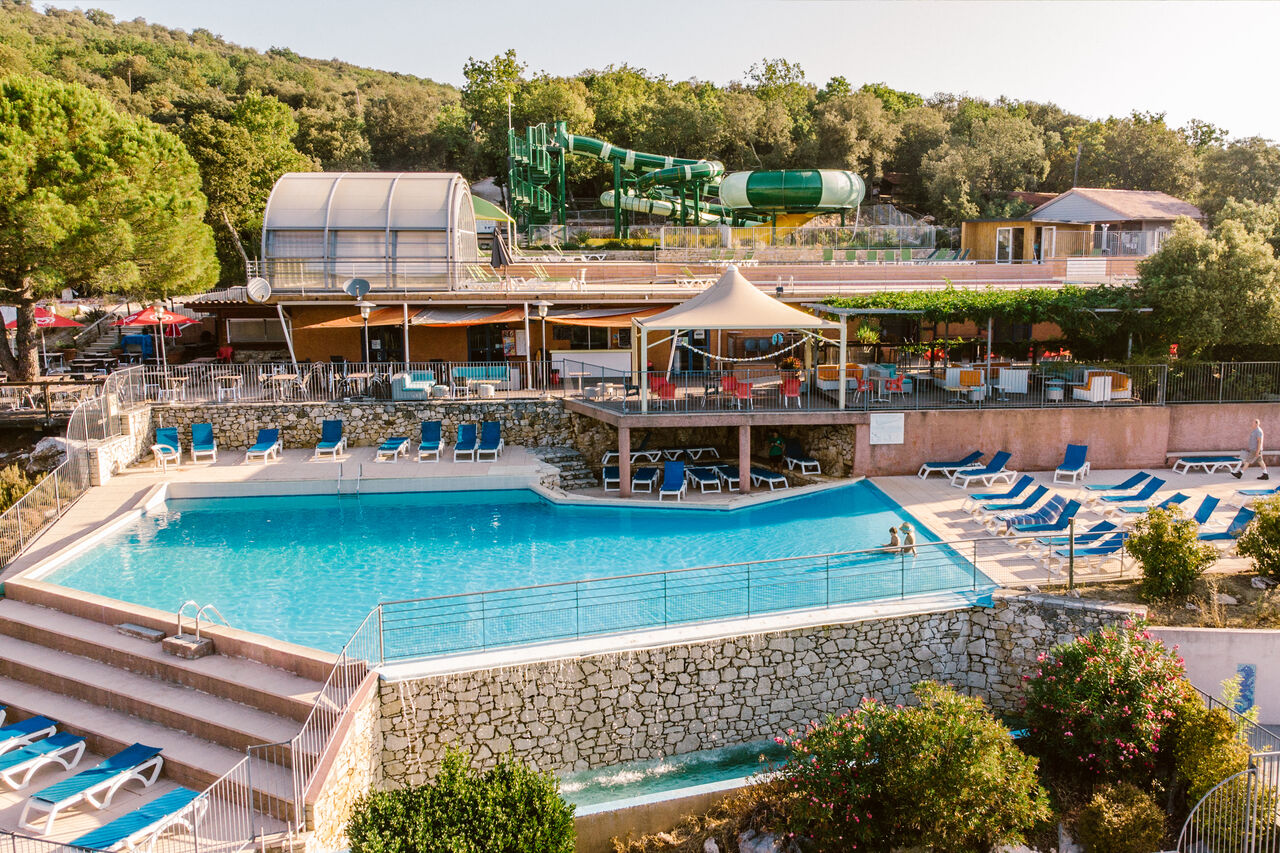 Outdoor swimming pool, water slides and restaurant at LIBRANOO Naturiste Sabliere campsite in Barjac (30).