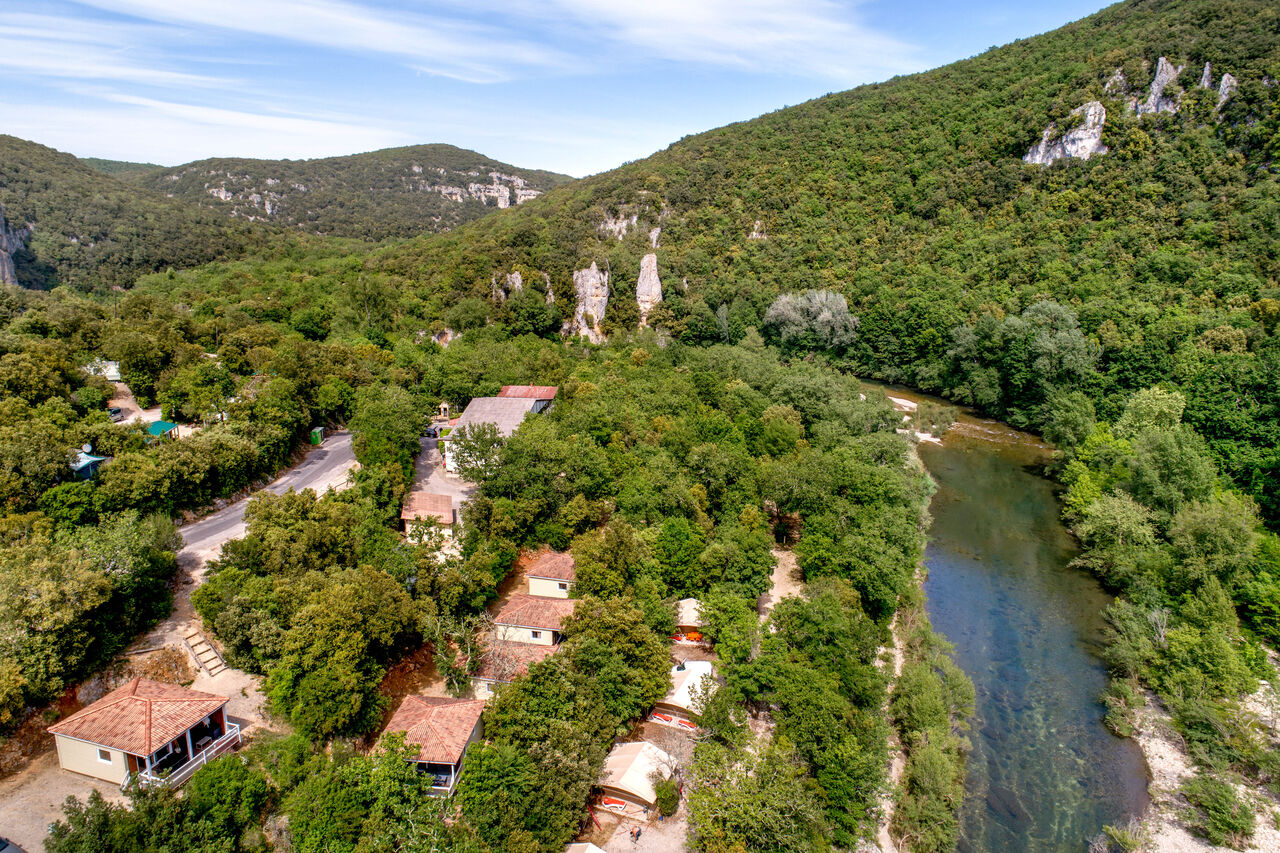 Aerial view of campsite, river, accommodations and lush nature at LIBRANOO Naturiste Sabliere campsite in Barjac (30).