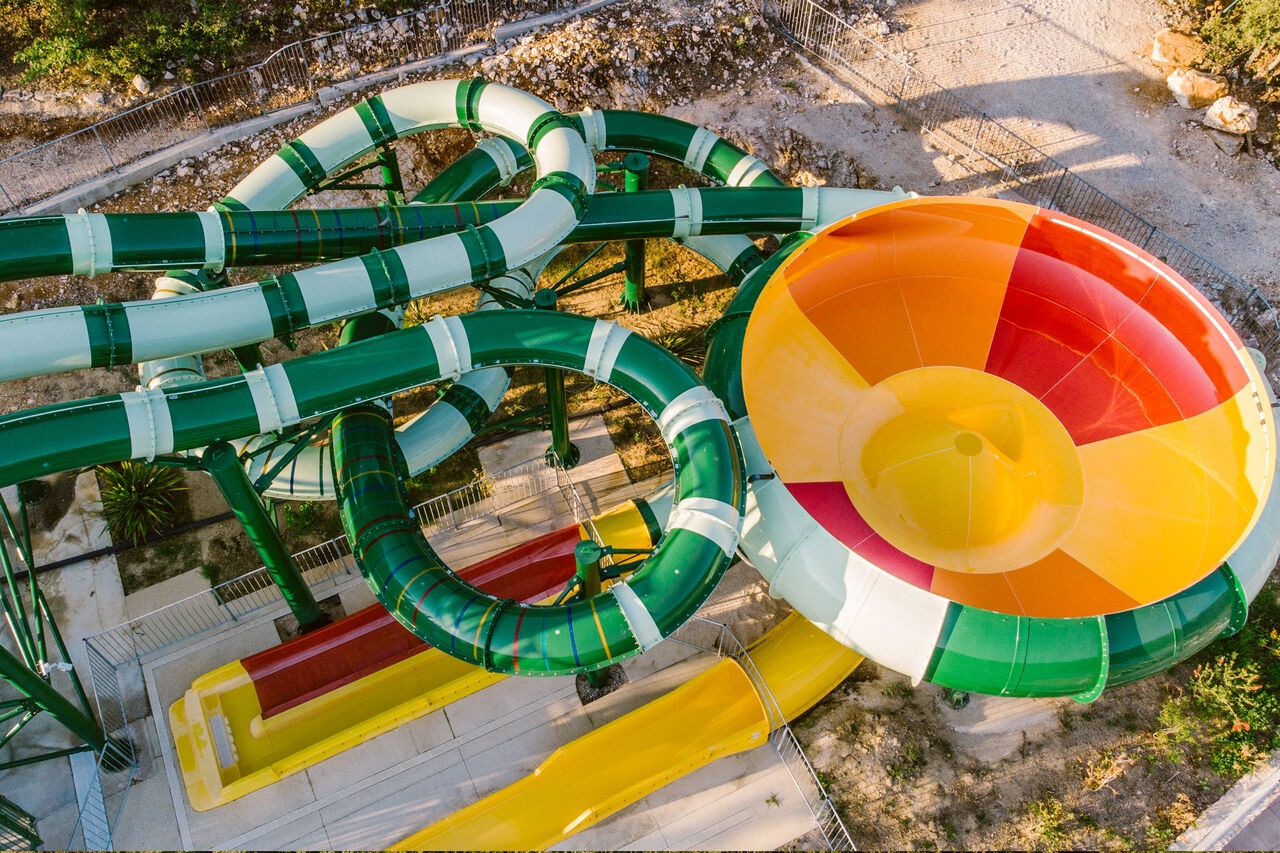 Giant water slides, colorful funnel, and fast descents at LIBRANOO Naturiste Sabliere campsite in Barjac (30).
