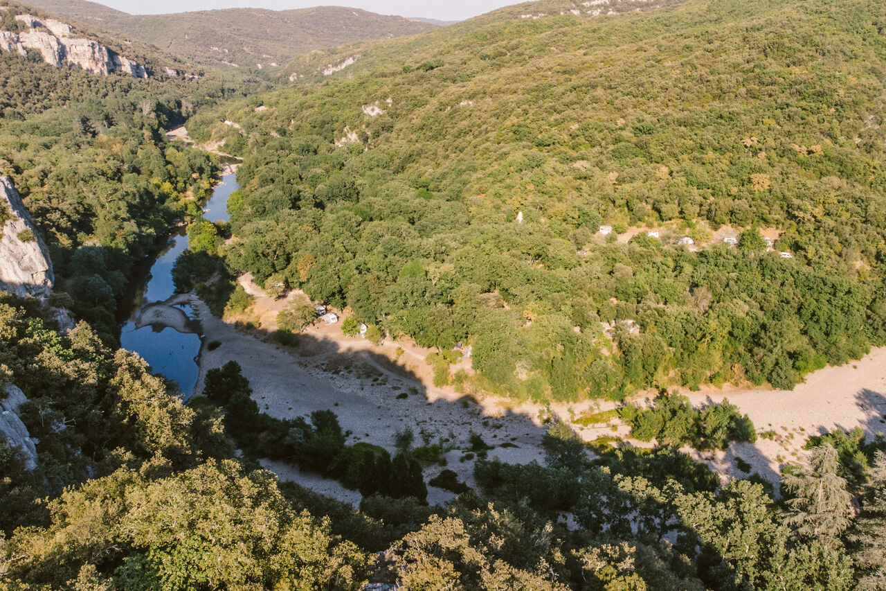 Aerial view river, forest, camping pitches LIBRANOO Naturiste Sabliere in Barjac (30).