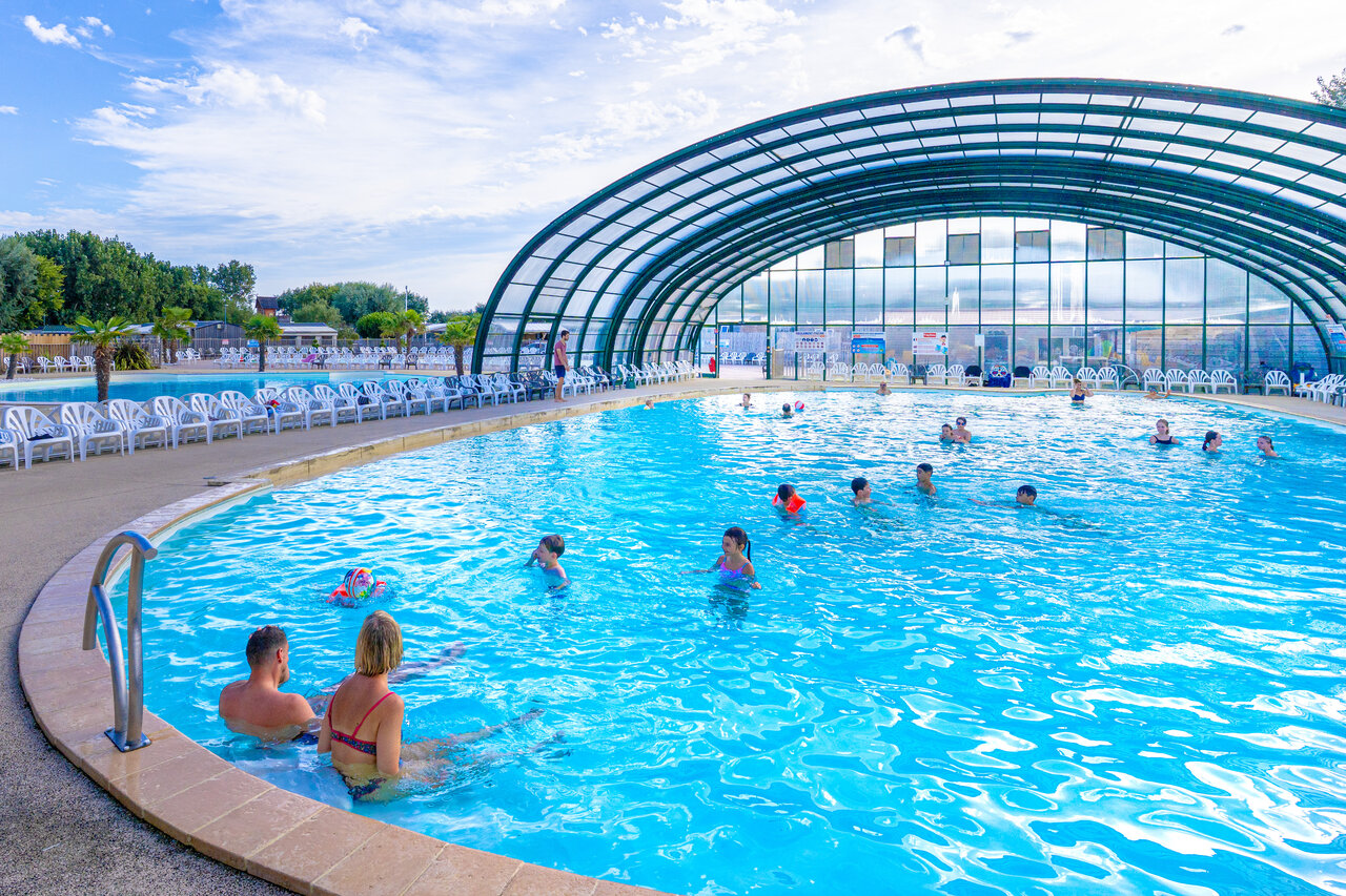 Covered swimming pool with bathers at CAPFUN Donjon de Lars campsite in Courseulles-sur-Mer (14).