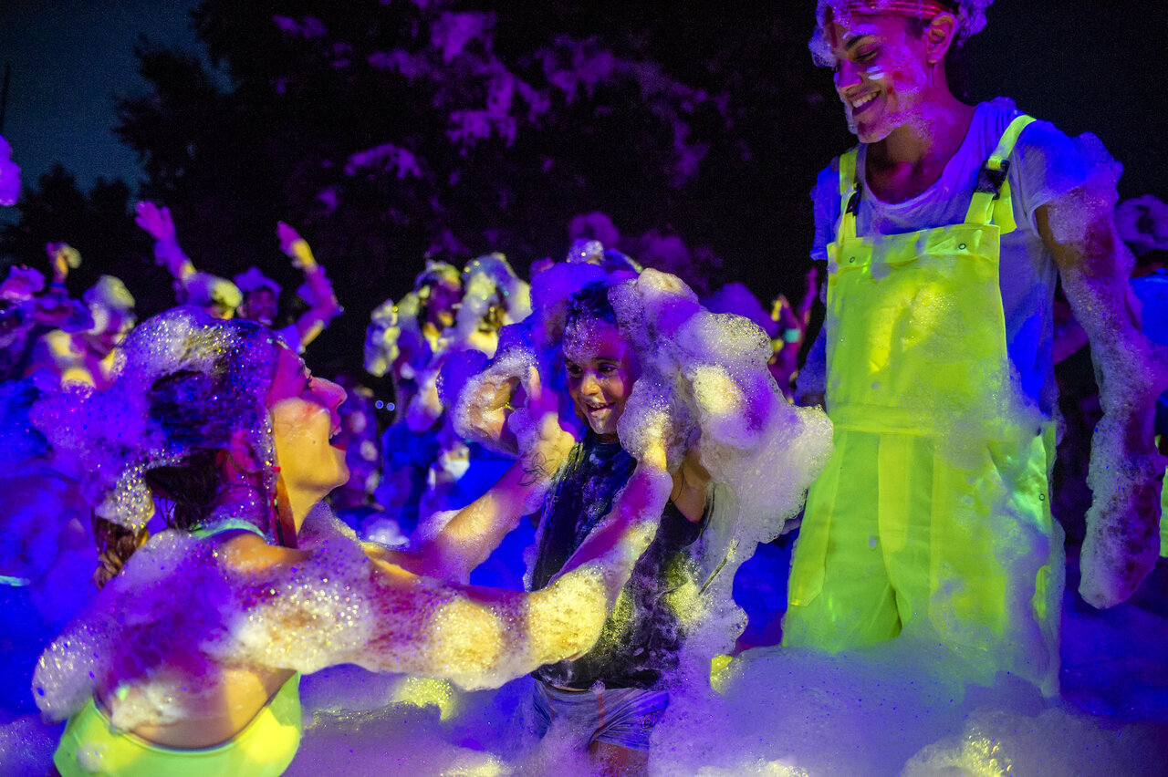 Lively fluorescent foam party, happy campers at CAPFUN Donjon de Lars campsite.