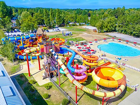 Colorful water slides and large outdoor swimming pool from above at CAPFUN Dune Fleurie campsite in Quend Plage (80).