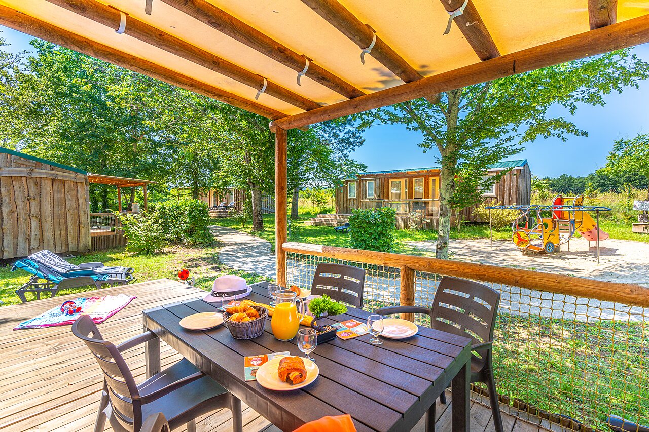 Mobile home terrace with breakfast, playground at CAPFUN Duravel (46).