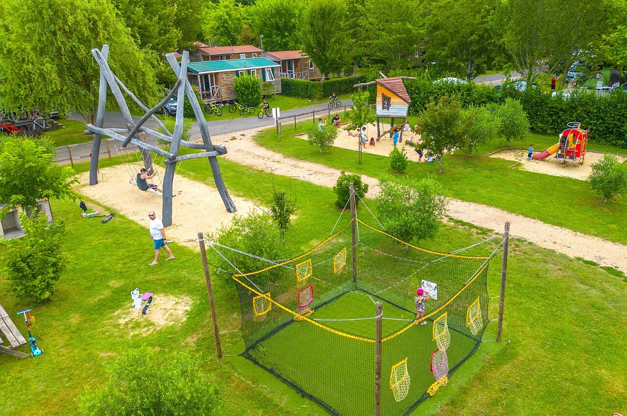 Giant swing, slide, playhouse, target games at CAPFUN Duravel campsite.