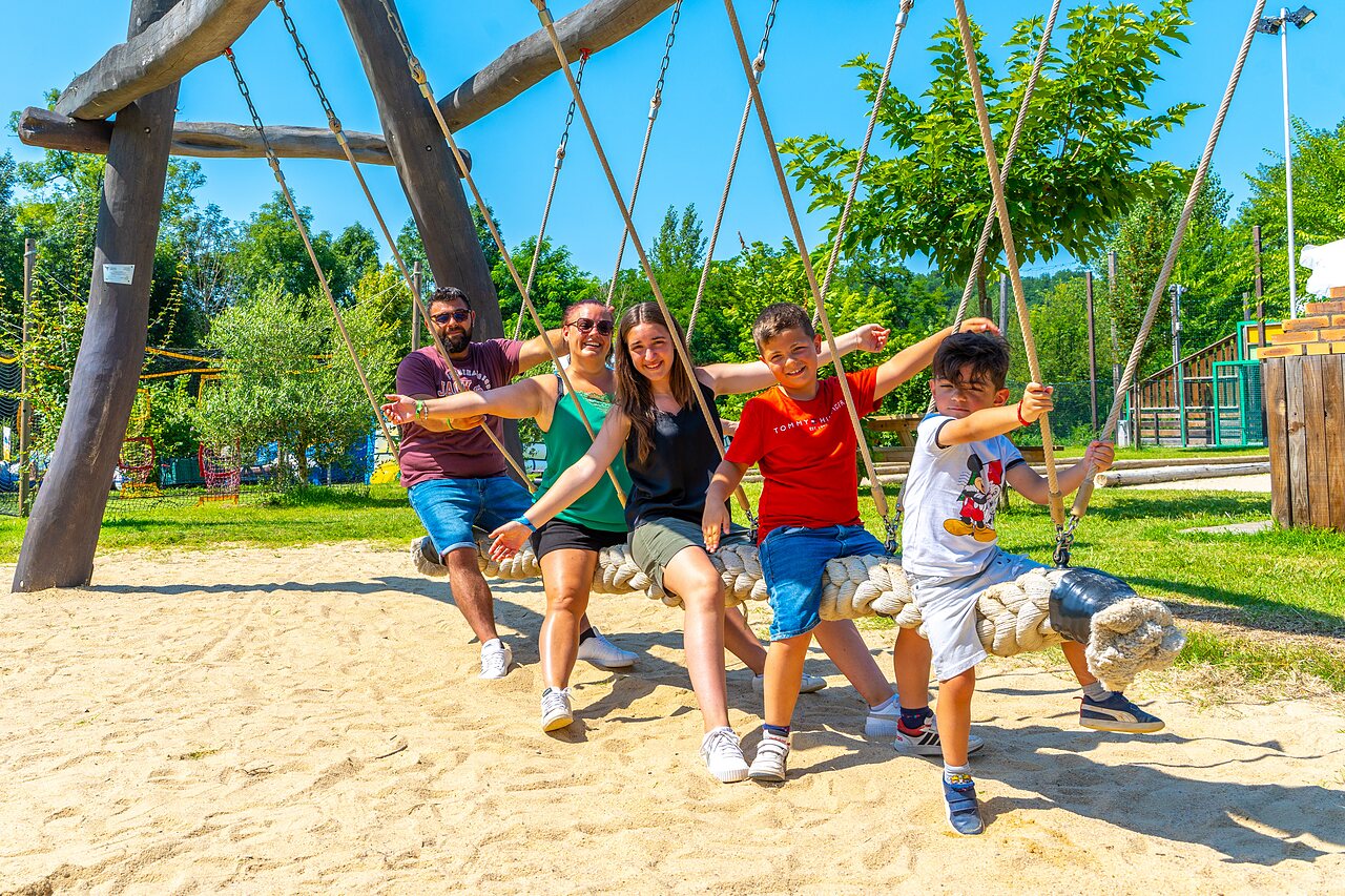 Happy family on a giant rope swing at CAPFUN Duravel campsite in Duravel (46).
