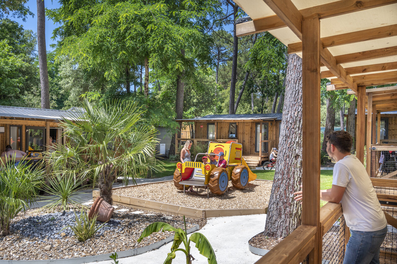 Wooden mobile homes and children's playground at CAPFUN Ecureuils JARD SUR MER (85).