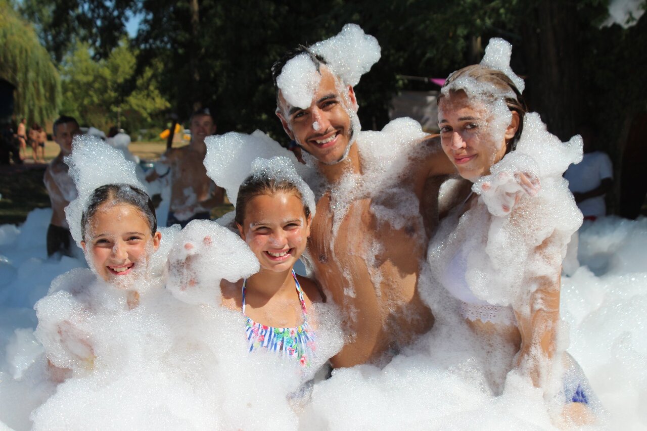 Smiling family and children at the foam party at CAPFUN Ecureuils campsite in JARD SUR MER (85).