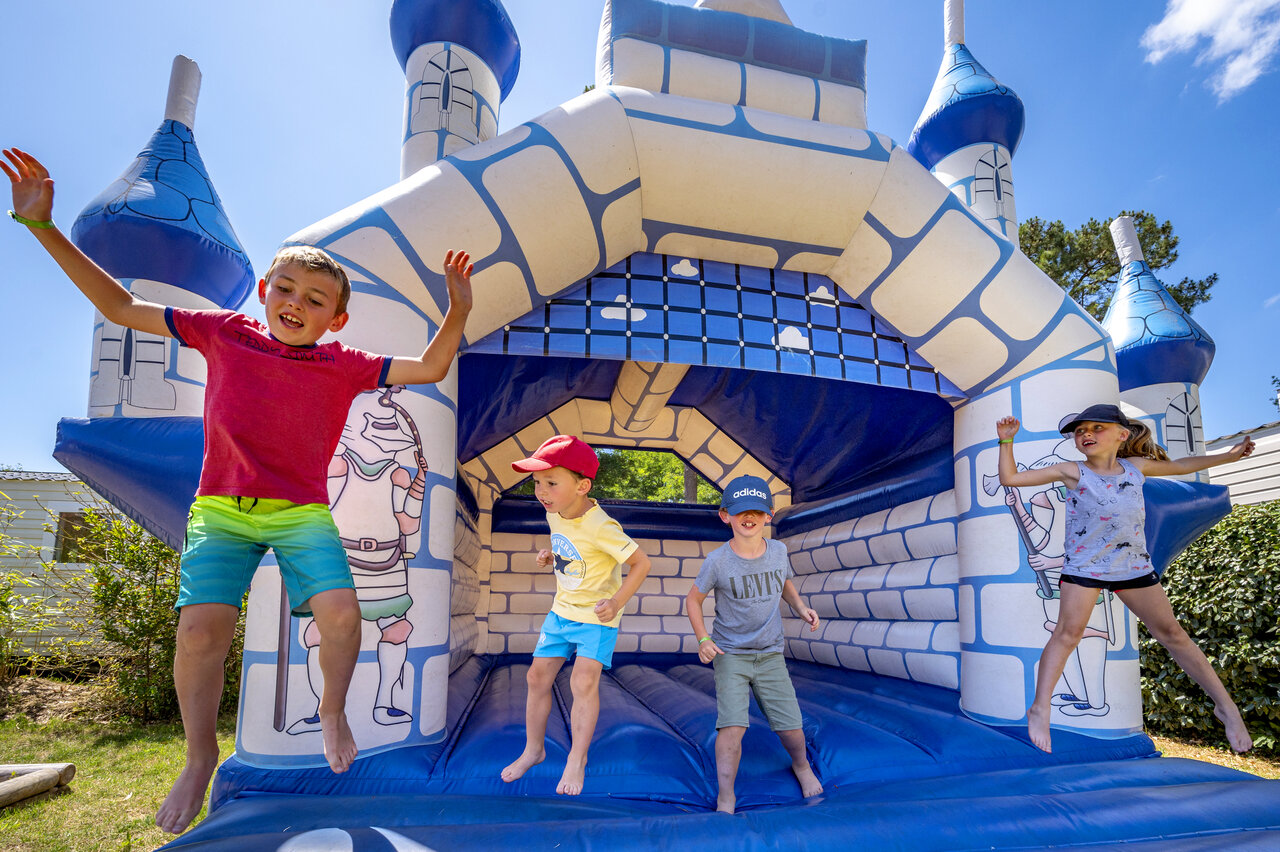 Inflatable castle with happy children at CAPFUN Ecureuils campsite in JARD SUR MER (85).