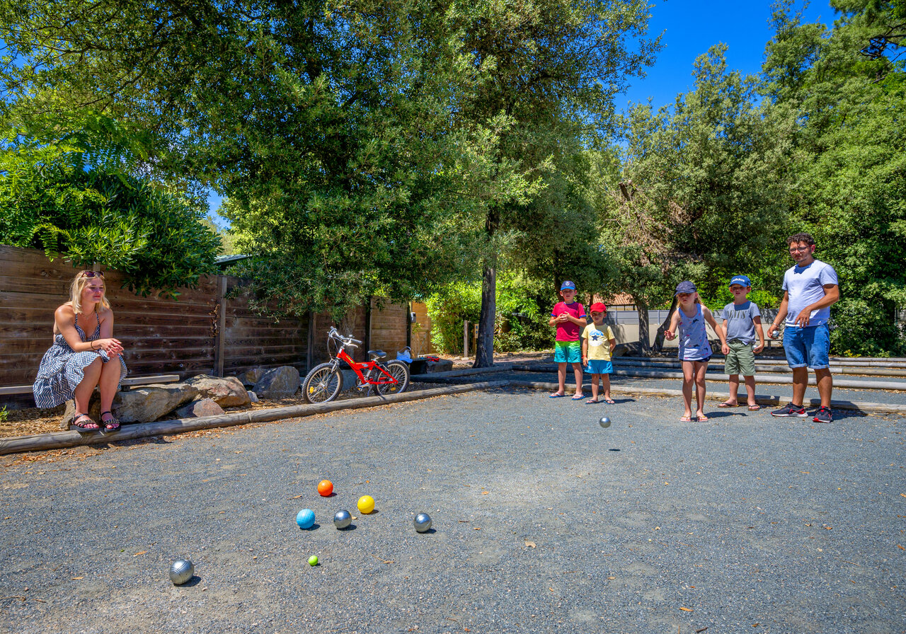 Shaded p�tanque court, family playing at CAPFUN Ecureuils campsite in JARD SUR MER (85).