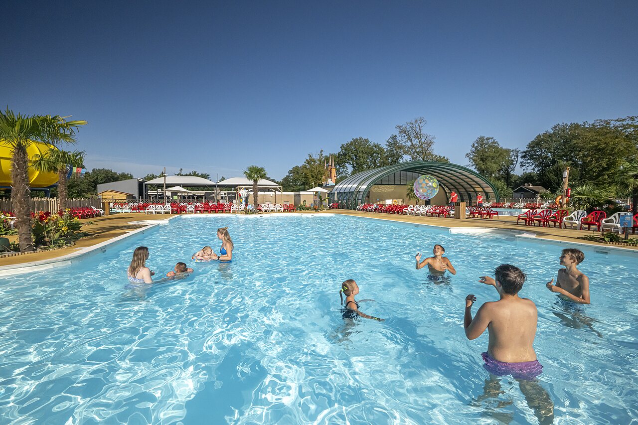 Large outdoor swimming pool with slide and families at CAPFUN Eibernest campsite in Eibergen.