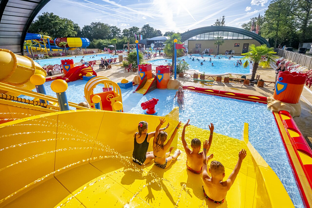 Children enjoying giant water slide and pools at CAPFUN Eibernest campsite in Eibergen.