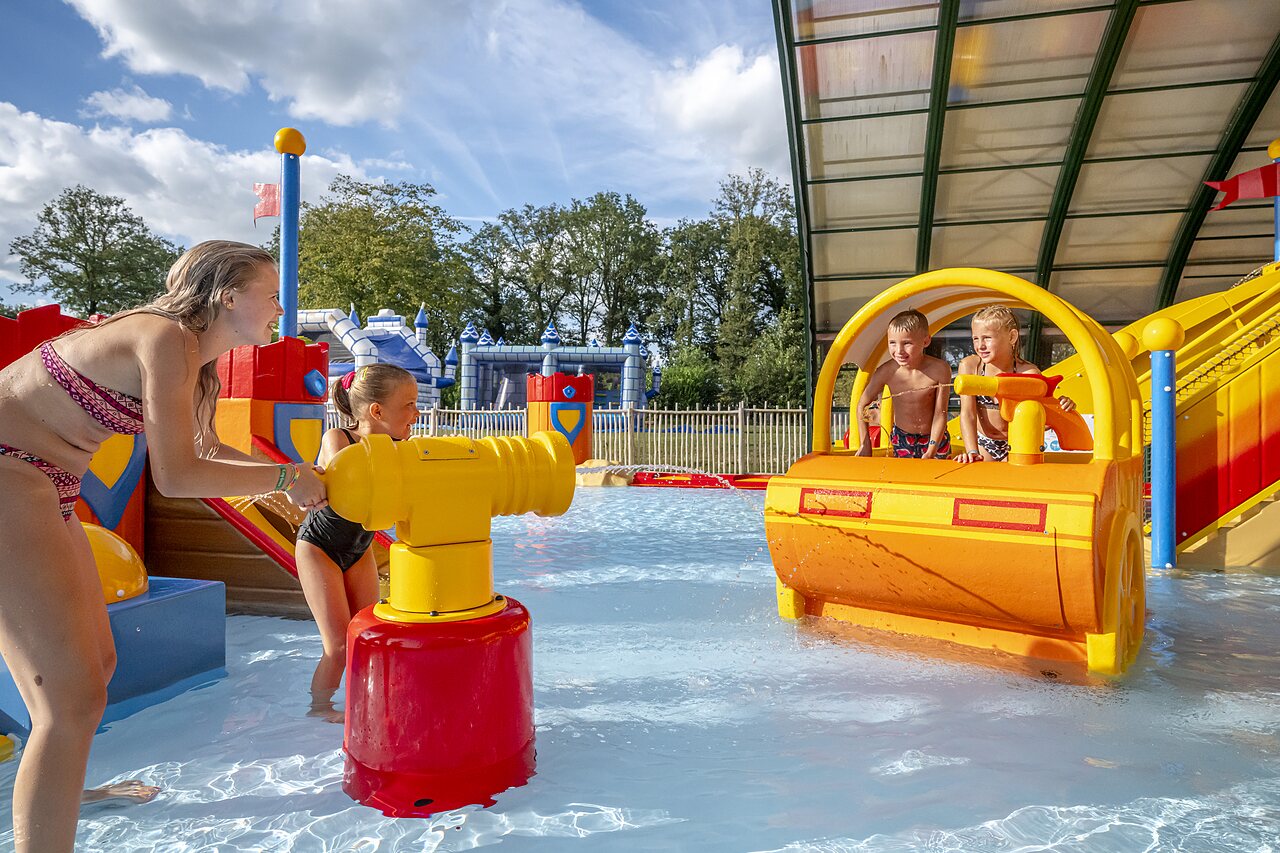 Children playing with water cannons and aquatic structures at CAPFUN Eibernest campsite in Eibergen