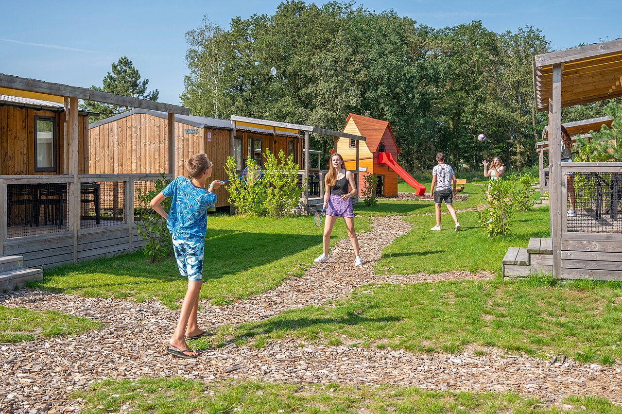 Children playing badminton near mobile homes at CAPFUN Eibernest campsite in Eibergen.