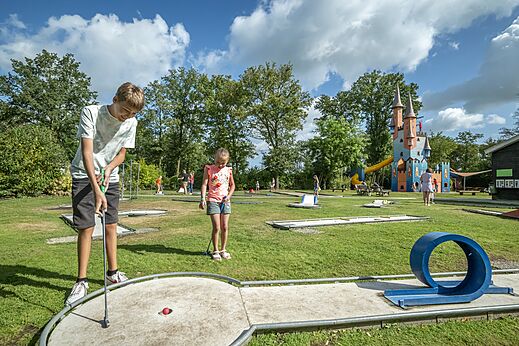 Children playing mini-golf with play castle at CAPFUN Eibernest campsite in Eibergen.