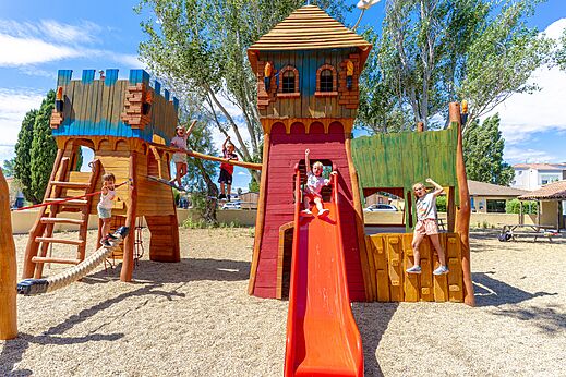 Wooden playground, slide, children at VAGUES OCEANES Elysée campsite, Le Grau du Roi.