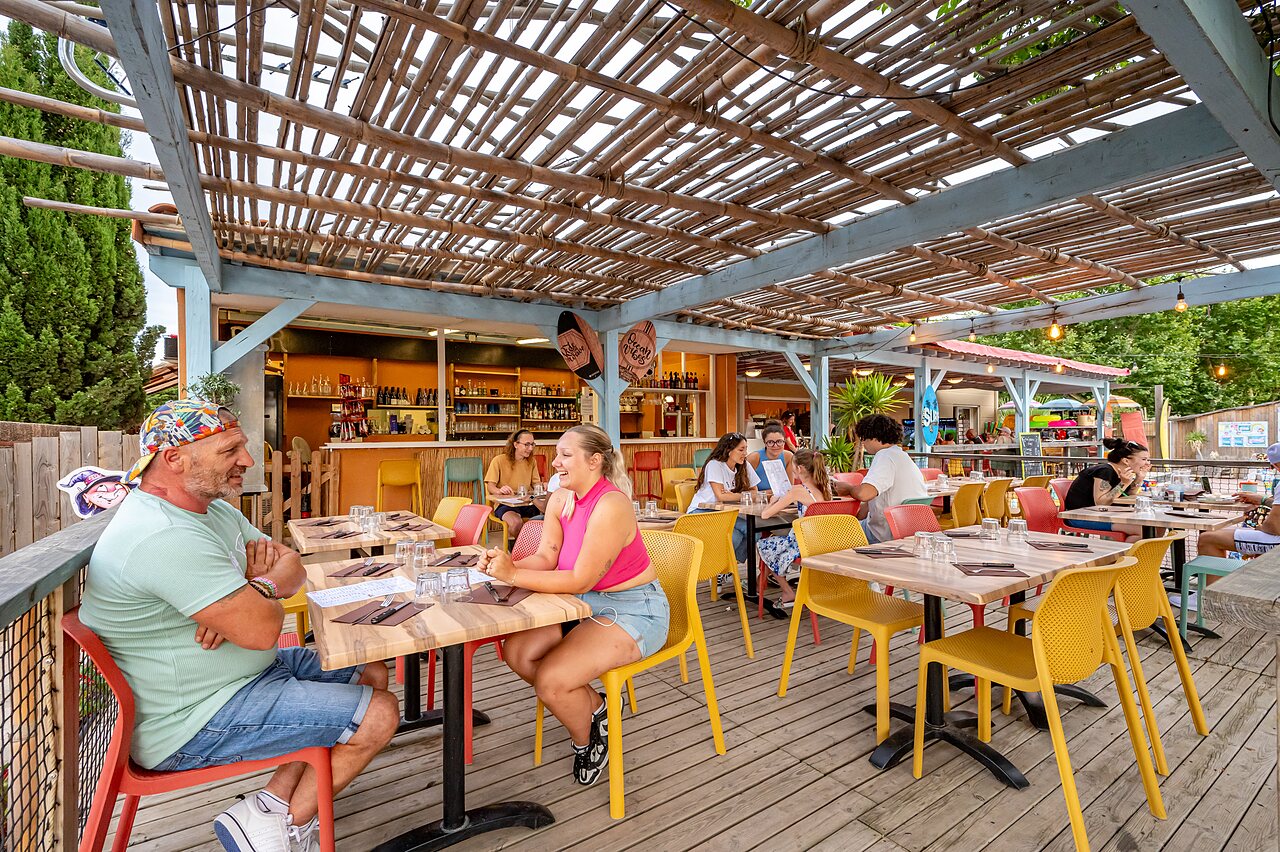Lively restaurant terrace with outdoor bar at CAPFUN El Moli campsite in Elne (66).