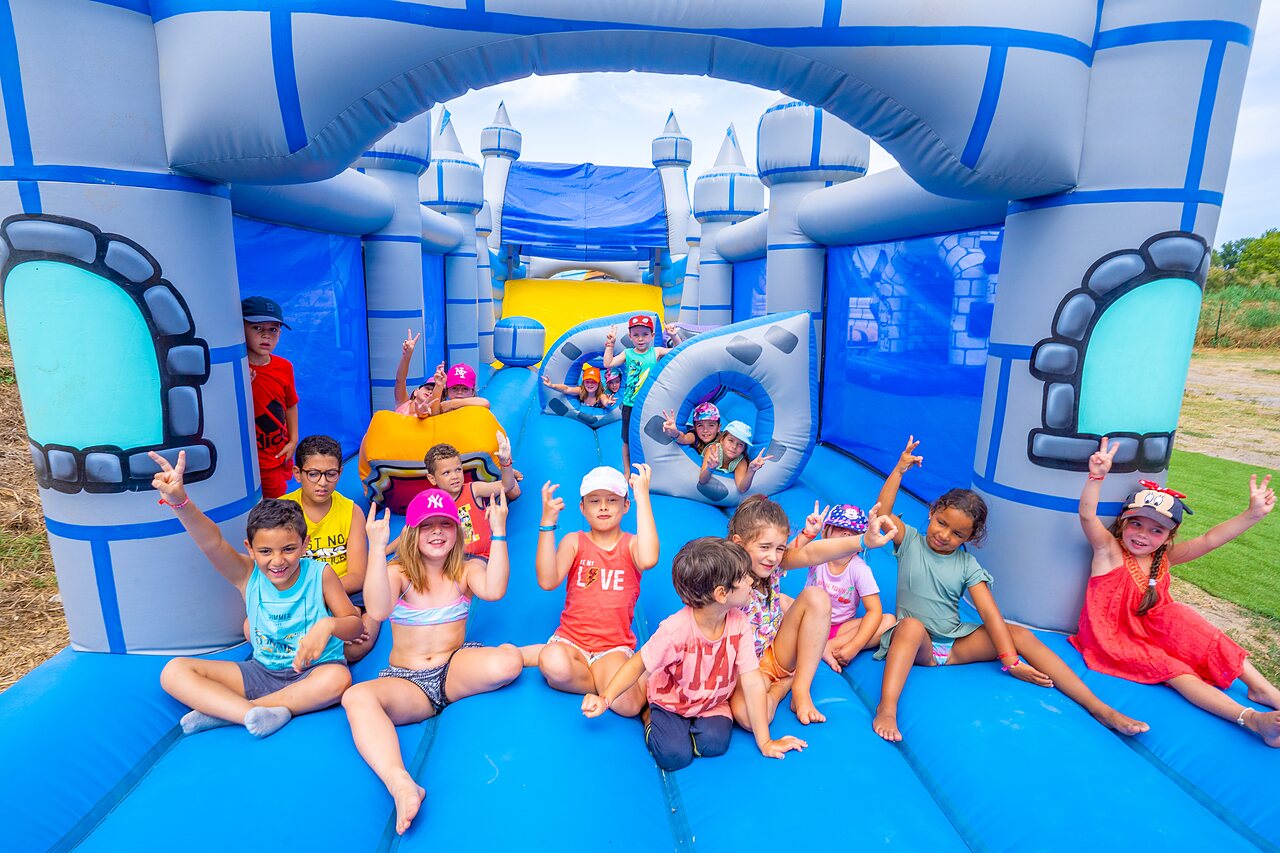 Inflatable castle and happy children at CAPFUN El Moli camping in Elne (66).
