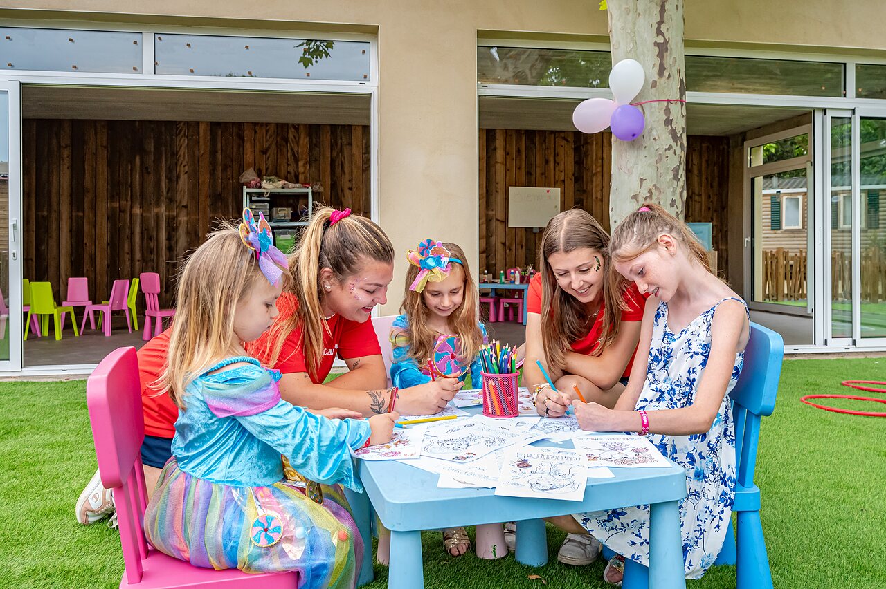 Children and animators coloring together at CAPFUN El Moli campsite in Elne (66).