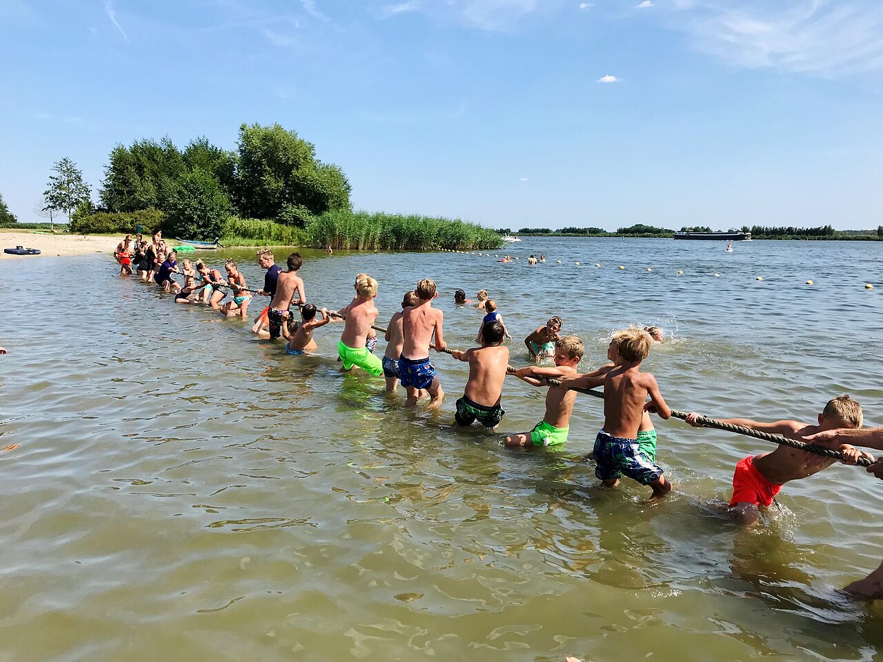 Tug-of-war for children in the water at CAPFUN Erkemederstrand Zeewolde.