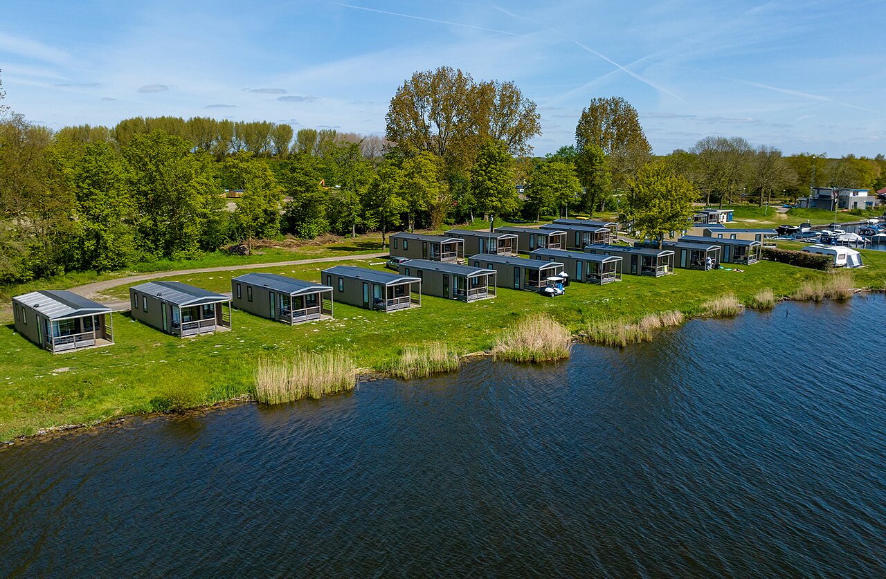 Modern mobile homes by water, aerial view at CAPFUN Erkemederstrand campsite Zeewolde.