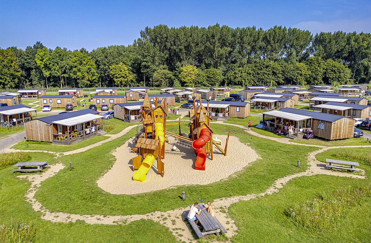 Playground, mobile homes and greenery at CAPFUN Erkemederstrand campsite in Zeewolde.