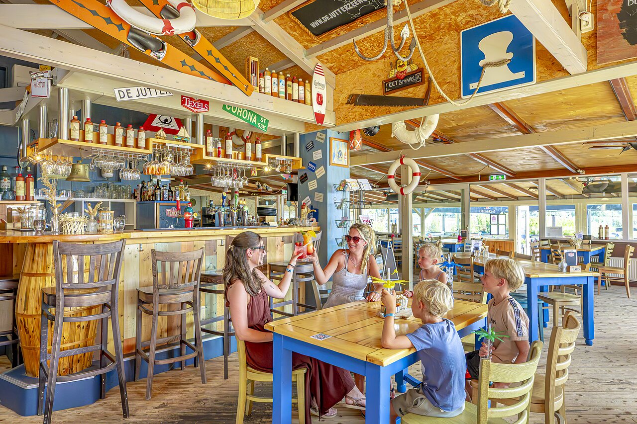 Family bar and restaurant with adults and children at CAPFUN Erkemederstrand campsite in Zeewolde.