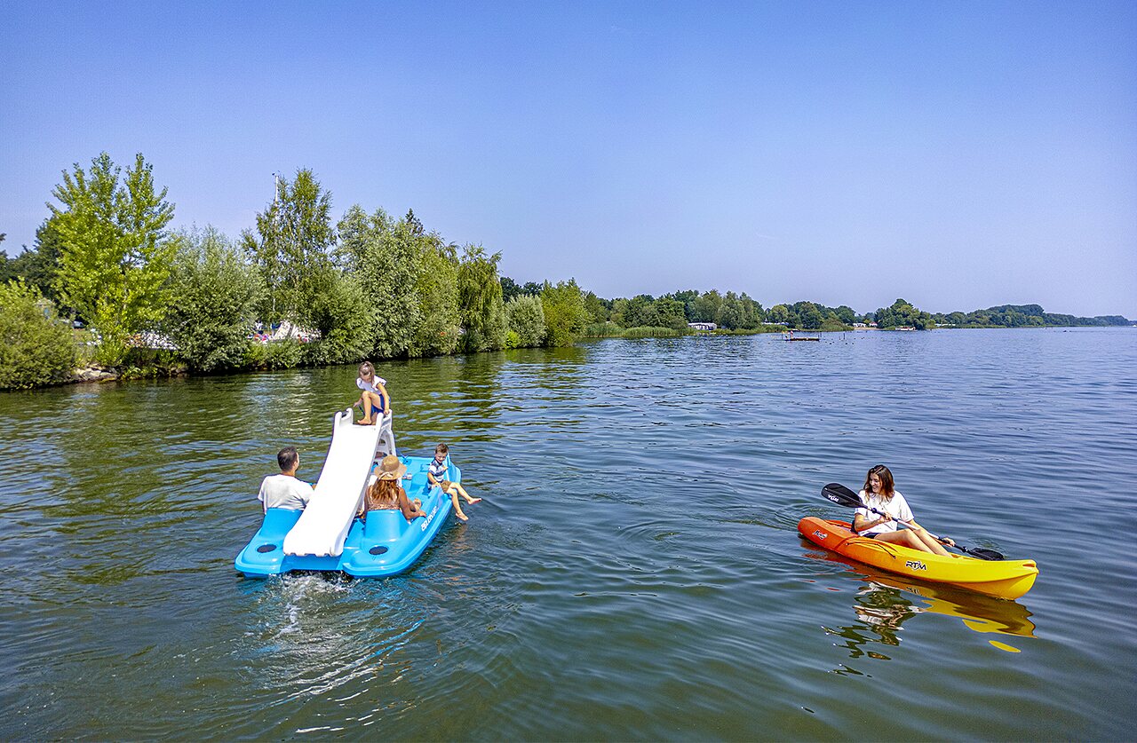 Pedal boat with slide, kayak on lake at CAPFUN Erkemederstrand campsite.