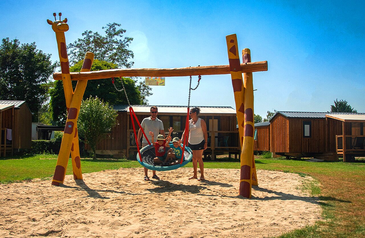 Family enjoying a giraffe nest swing at VAGUES OCEANES Lac d'Erstein campsite in Erstein (67).
