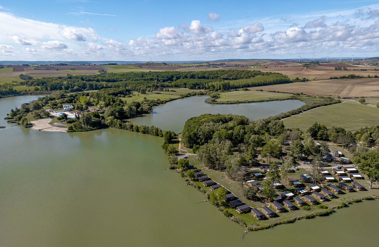 Aerial view of the lake, mobile homes, and pool at camping CLICOCHIC Etang de la Mutche in HARPRICH (57).