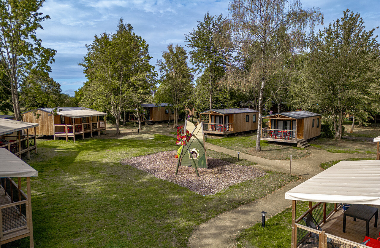 Wooden chalets, children's playground at CLICOCHIC campsite in HARPRICH.